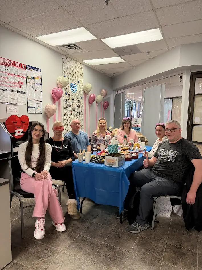 Staff celebrate Valentine’s Day around a table with heart balloons and treats at the European Service home care office in Niles, Illinois.